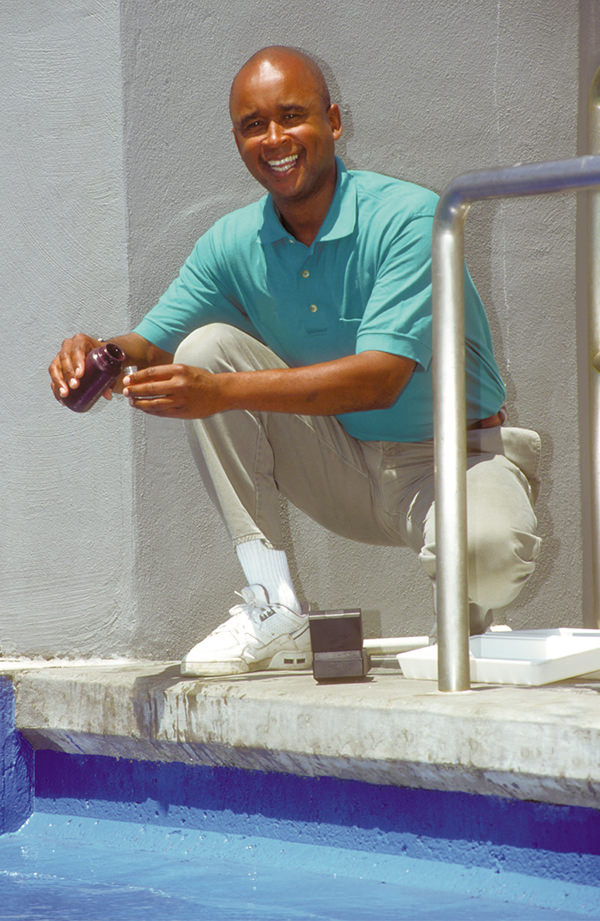 An aquarist samples water from an aquarium